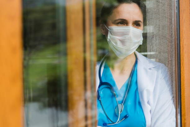 Female doctor looking through window at hospital