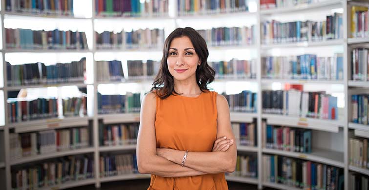 Female Librarian surrounded by library bookshelves