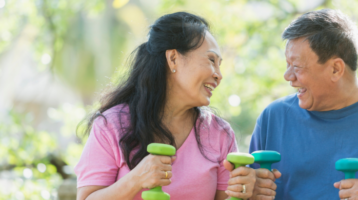 Woman and Man Work Out With Weights In Park