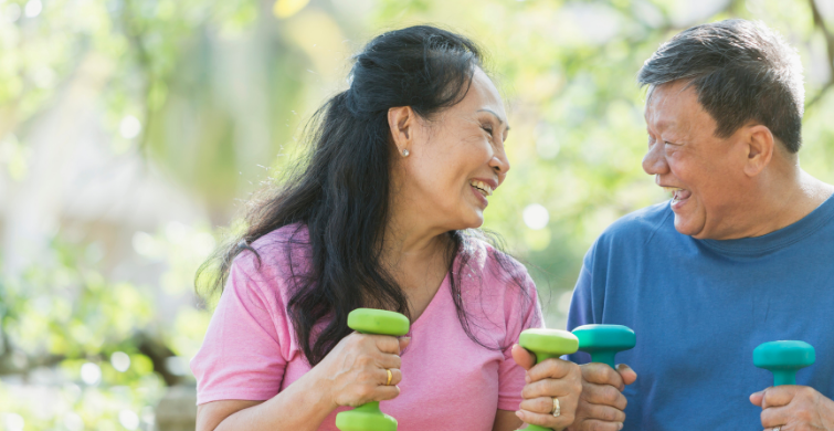 Woman and Man Work Out With Weights In Park