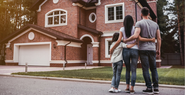 Family stands in front of home