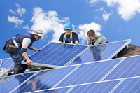 three men install solar panels 